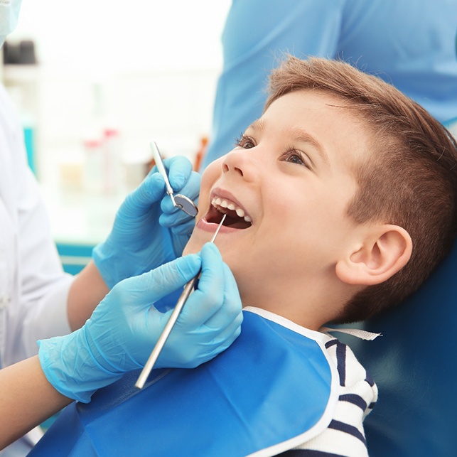 A dentist examining a little boy’s mouth