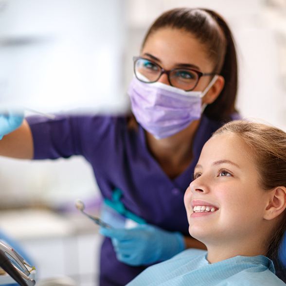 Child in dental chair with female dentist looking at dental footage