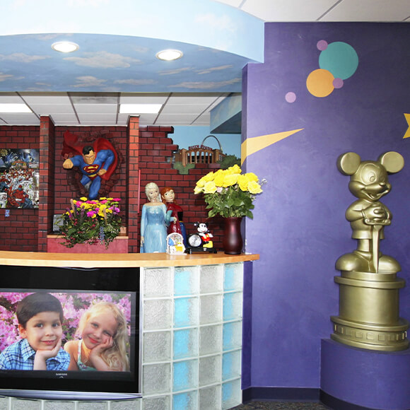 Disney figures and Superman behind pediatric dental office reception desk