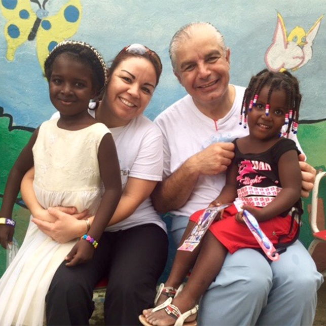 Dentist dental team member and two children on dental mission trip