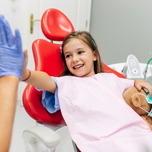 Young girl high-fiving dentist in Chesterfield