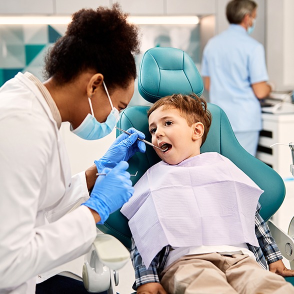 a pediatric dentist examining a child’s teeth