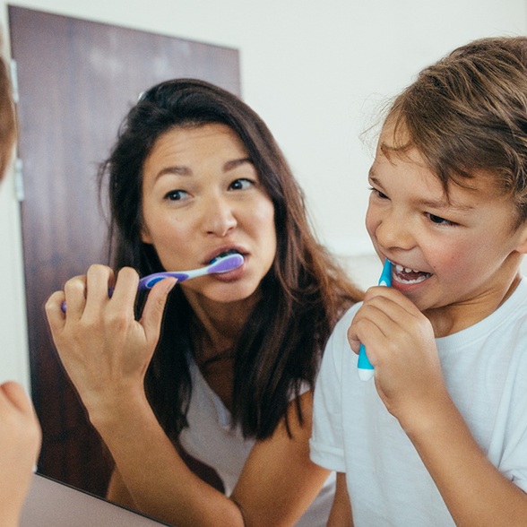 a mom brushing her teeth with her son