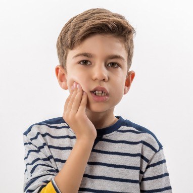 Little boy with toothache holding cheek