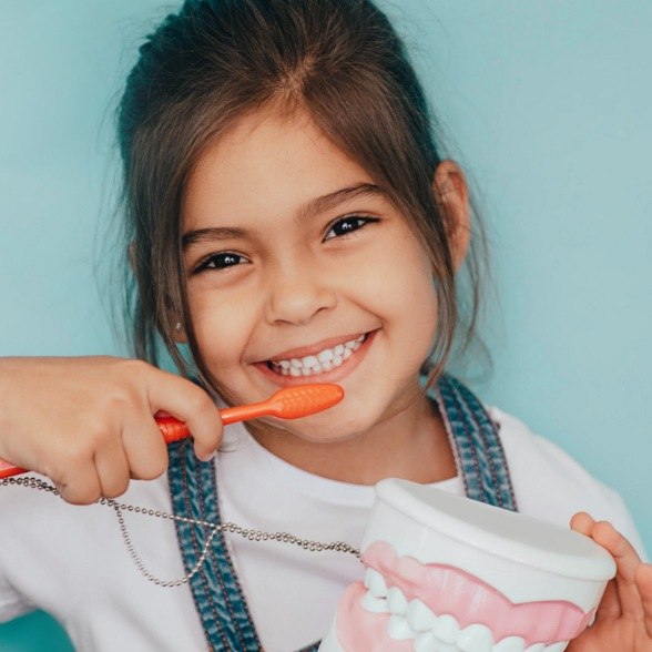 Little practing tooth brushing to prevent dental emergencies