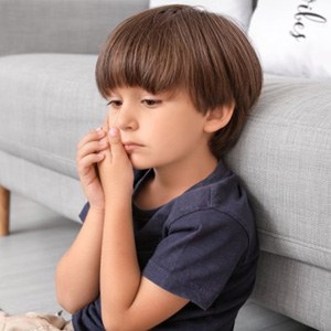a child holding his cheek due to tooth pain