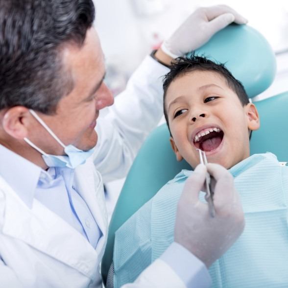 Dentist checking child's smile after tooth extraction