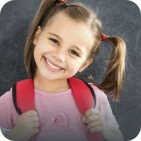 Smiling little girl with pigtails wearing backpack