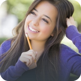Teen girl smiling and holding pencil