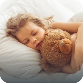 Child sleeping while holding teddy bear