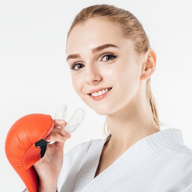 Teen girl holding an athletic mouthguard