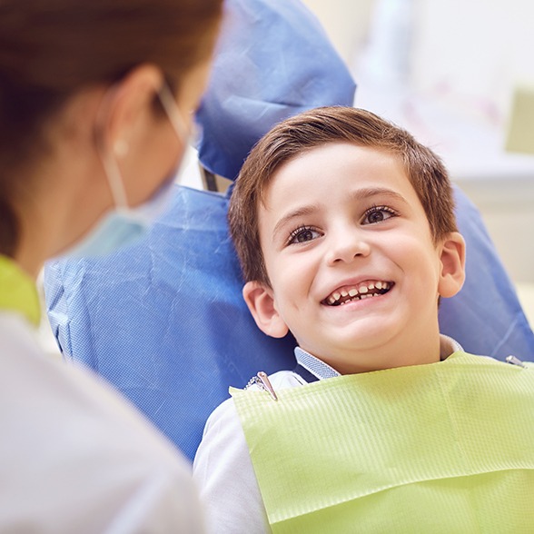 a young boy talking to a pediatric dentist
