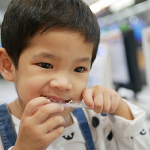 closeup of child chewing on wrapper