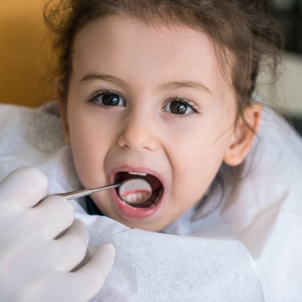 Dentist examining child's tooth colored fillings