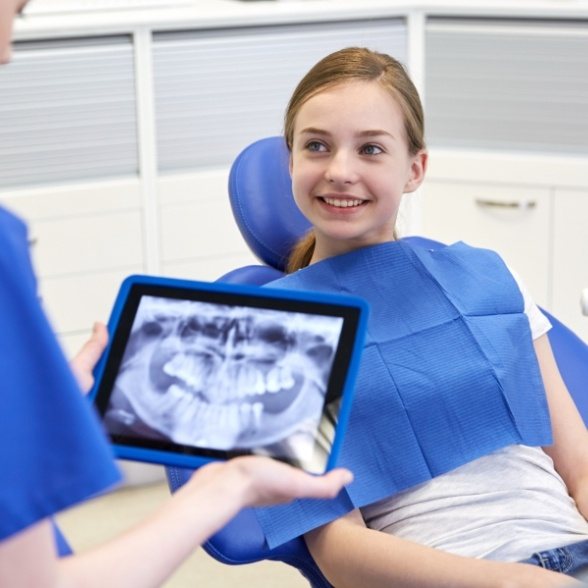 Dentist looking at digital dental x-rays on tablet computer