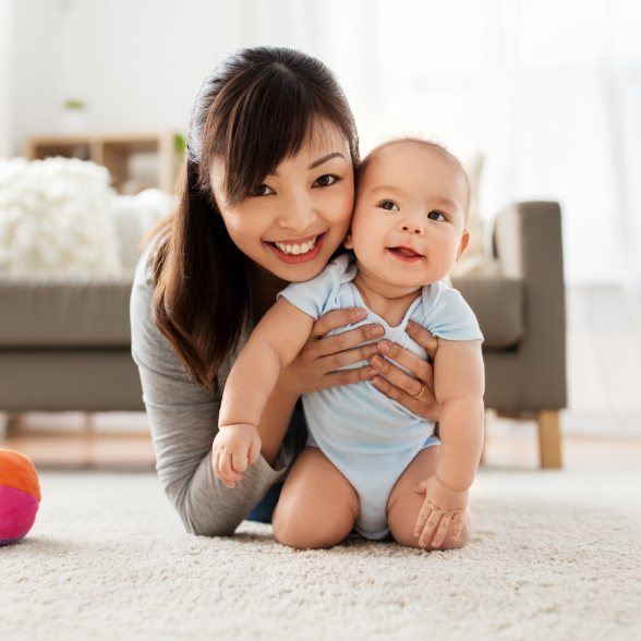 Mother holding her smiling baby after dentistry for infants