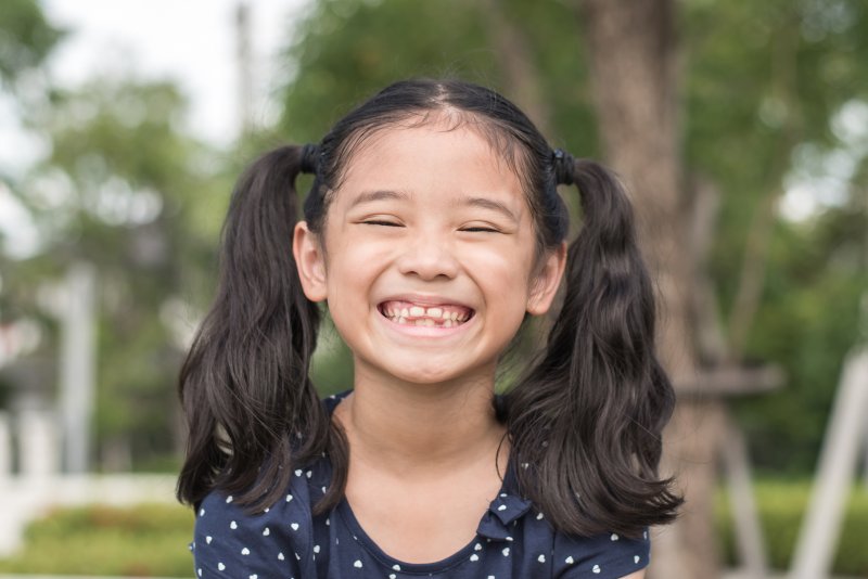 a little girl wearing her hair in pigtails and showing off her smile in Chesterfield