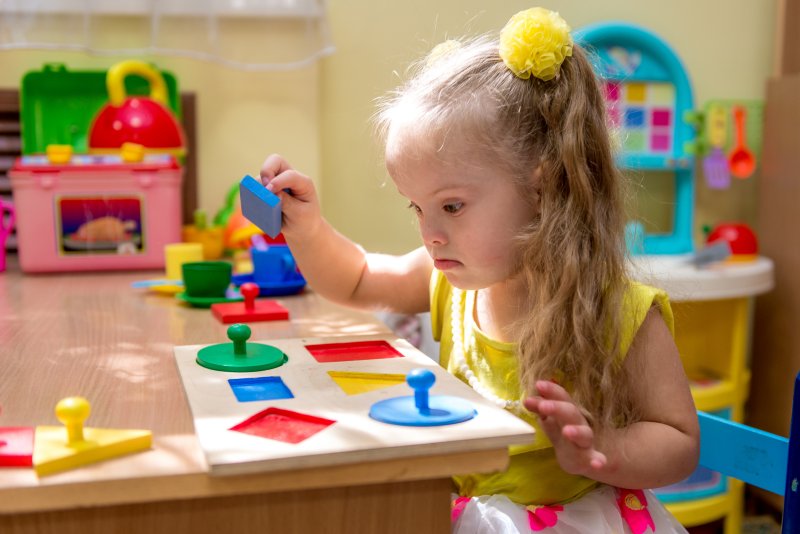 girl with special needs playing with a toy