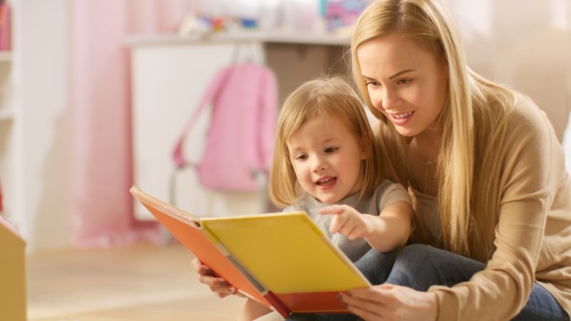 mother reading to little girl about dental visit