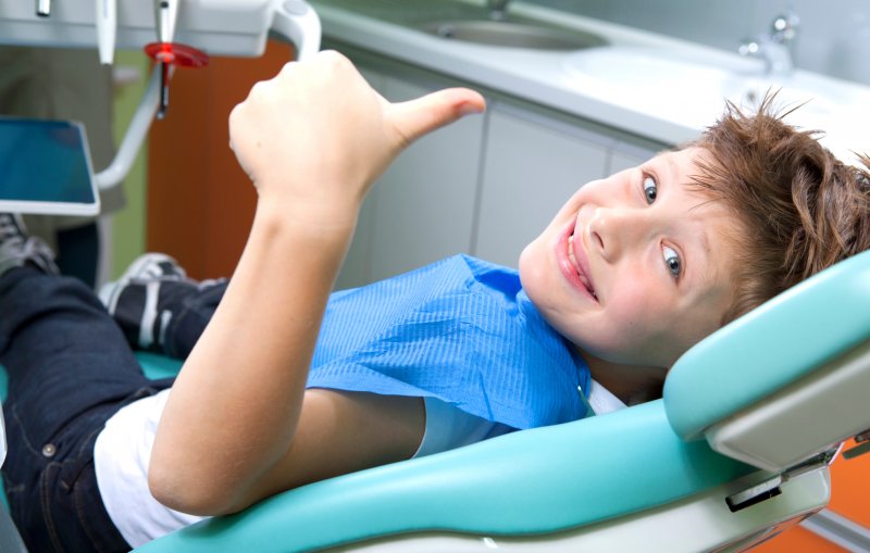 Child giving thumbs up before general anesthesia