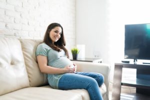 Pregnant woman relaxing while looking at her belly