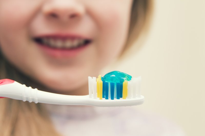 A closeup of a little girl with a toothbrush