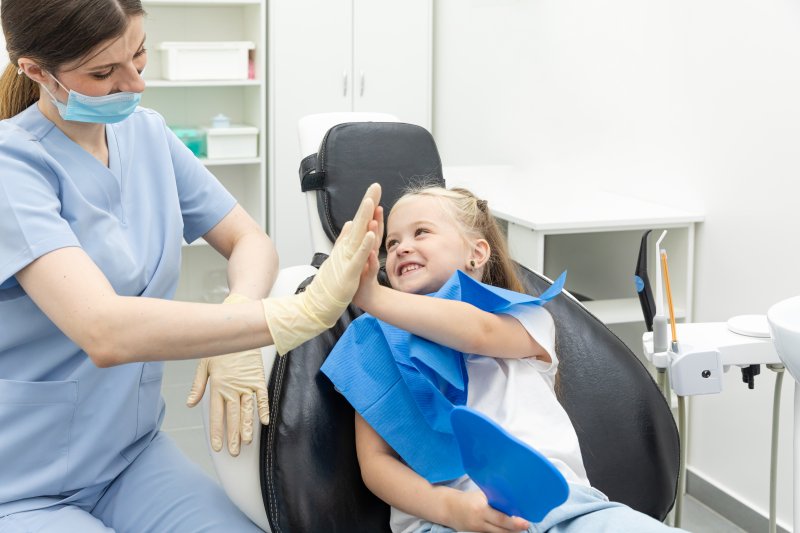 Dentist slapping hands with young patient