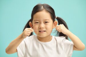 Child flossing teeth. 