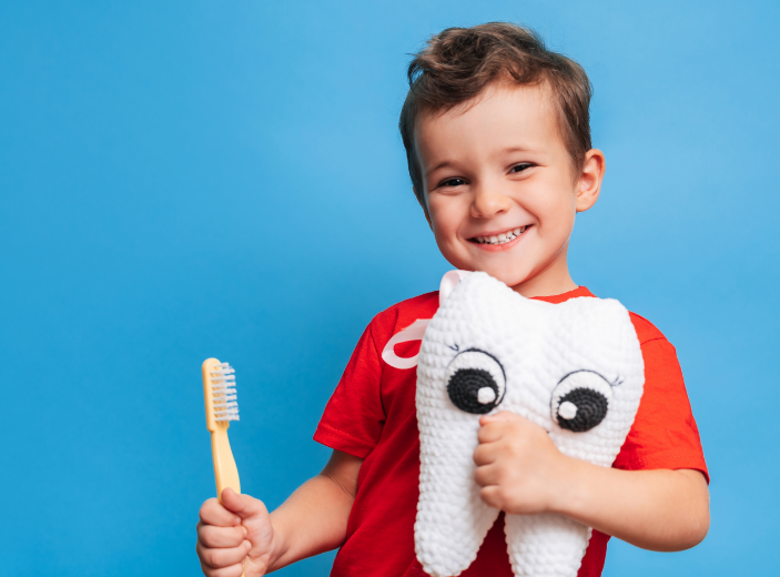 Boy with a toothbrush and tooth plushie