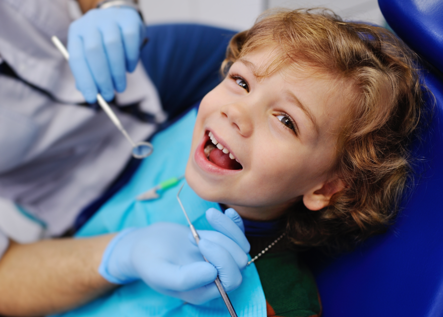 Child in dental chair, smiling